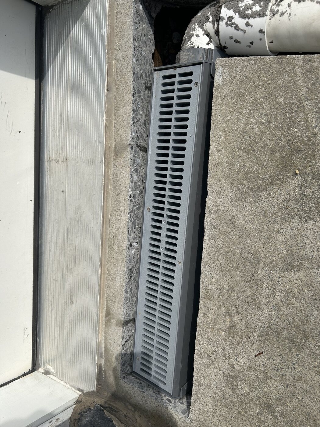 Channel drain installed beside the entryway